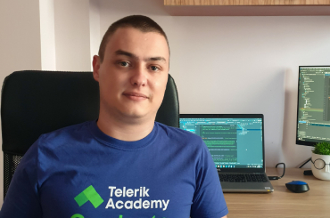 photo of ivan with telerik academy alpha graduation t-shirt in front of a computer screens with code